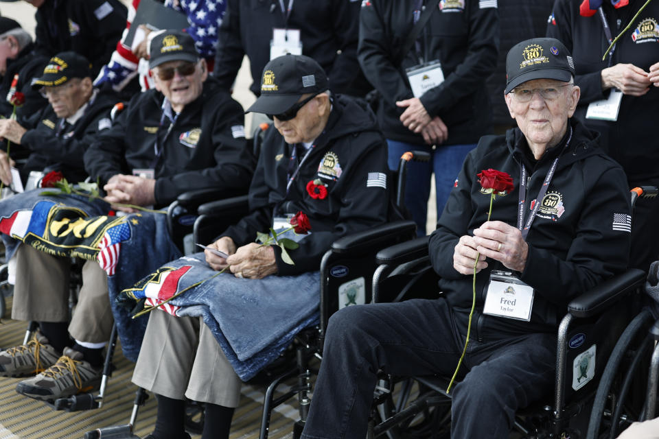 American WW II veteran Fred Taylor, right, and others hold roses during a wreath-laying ceremony at Utah Beach, Wednesday, June 5, 2024 at Utah Beach, Normandy,. World War II veterans from across the United States as well as Britain and Canada are in Normandy this week to mark 80 years since the D-Day landings that helped lead to Hitler's defeat. (AP Photo/Jeremias Gonzalez)