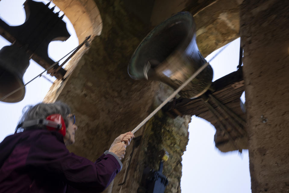 Roser Reixach, a student of the Vall d'en Bas School of Bell Ringers, performs playing a bronze bell at the church bell tower of the12th-century Sant Romà church, at the tiny village of Joanetes, about two hours north of Barcelona, Spain, Saturday, July 29, 2024. A school set up to revive the manual ringing of church bells has graduated its first class of 18 students after learning their ringing skills. (AP Photo/Emilio Morenatti)