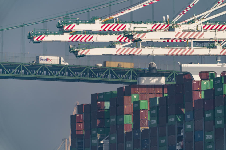 FILE - Transportation trucks cross the Vincent Thomas Bridge over the main channel as shipping containers are seen stacked on the Evergreen terminal at the Port of Los Angeles in San Pedro, Calif., Tuesday, Nov. 30, 2021. Contract negotiations between 22,000 workers at 29 West Coast ports and representatives of shipping companies will begin next week with automation and its impact on jobs emerging as a major point of contention amid supply chain issues. (AP Photo/Damian Dovarganes, File)