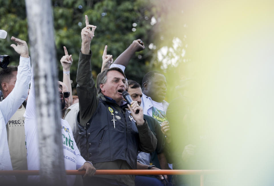 Brazil's President Jair Bolsonaro talks to supporters after joining a caravan of motorcycle enthusiasts through the streets of the city, organized to show support for Bolsonaro, in Sao Paulo, Brazil, Saturday, June 12, 2021. (AP Photo/Marcelo Chello)