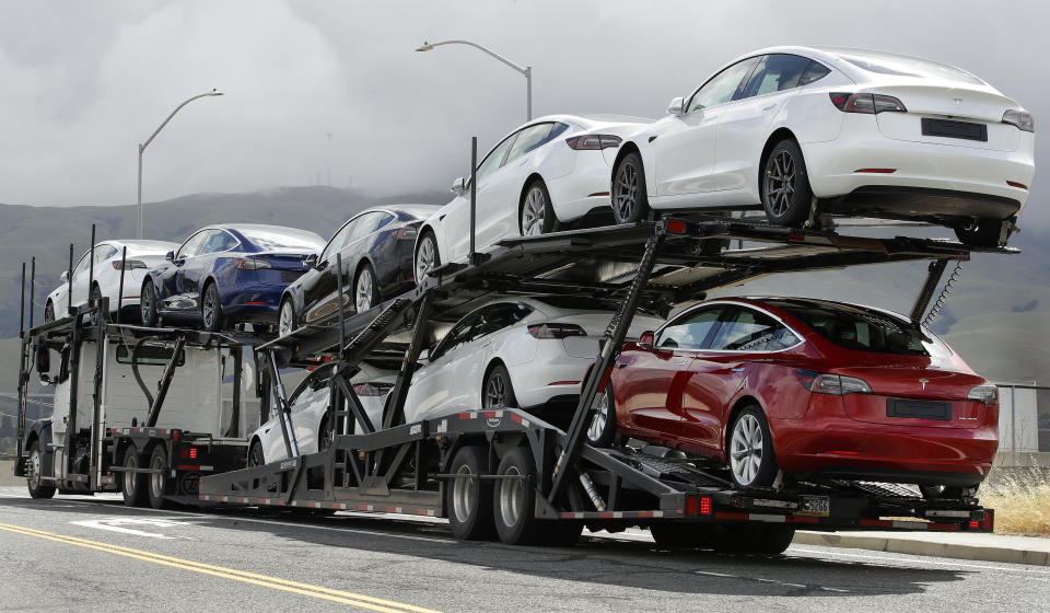 Een vrachtwagen vol met Tesla-auto's vertrekt op dinsdag 12 mei 2020 uit de Tesla-fabriek in Fremont, Californië. Elon Musk, CEO van Tesla, is naar voren gekomen als een kampioen in het negeren van thuisbevelen die bedoeld zijn om te voorkomen dat het coronavirus zich verspreidt, en krijgt ook steun als critici op sociale media. Een van de aanhangers was president Donald Trump, die dinsdag tweette dat Tesla's fabriek in San Francisco Bay Area open zou moeten mogen, ondanks het bevel van de gezondheidsafdeling om gesloten te blijven, behalve voor basisoperaties. (AP Foto/Ben Margot)