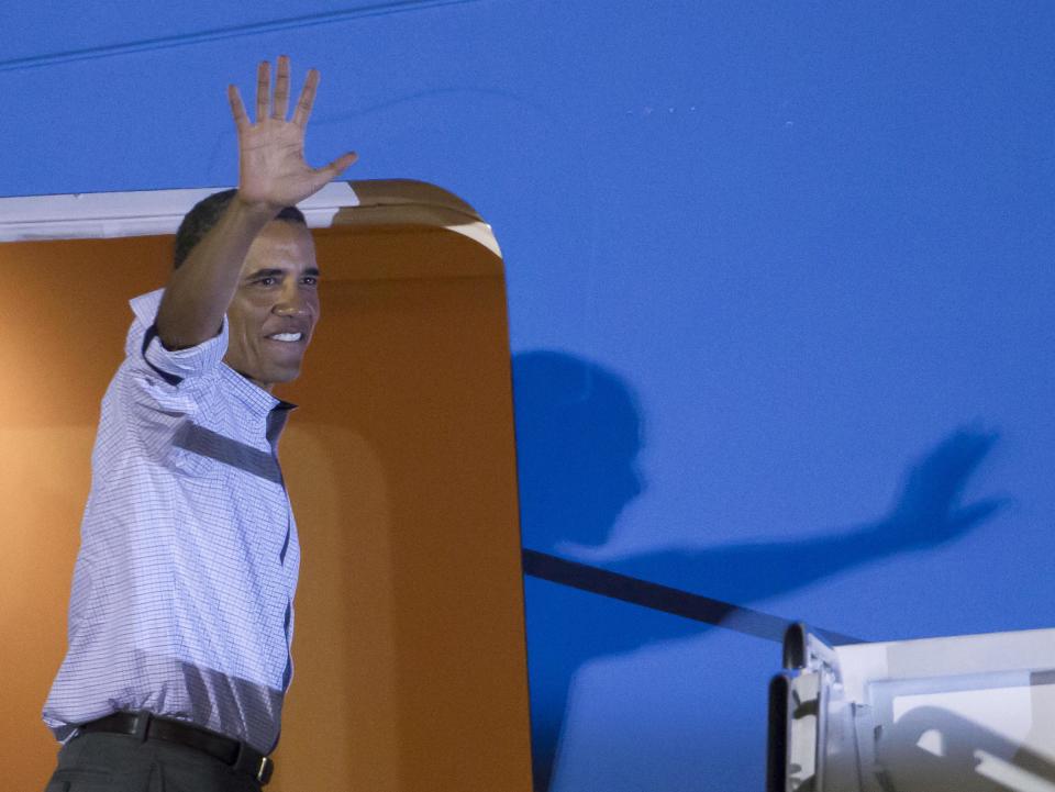 President Barack Obama waves to various Hawaii dignetaries before boarding Air Force One at Joint Base Pearl Harbor-Hickam to return to Washington Saturday, Jan. 4, 2014, in Honolulu. The President along with his family spent the last two weeks vacationing in Kailua, Hawaii. (AP Photo/Eugene Tanner)