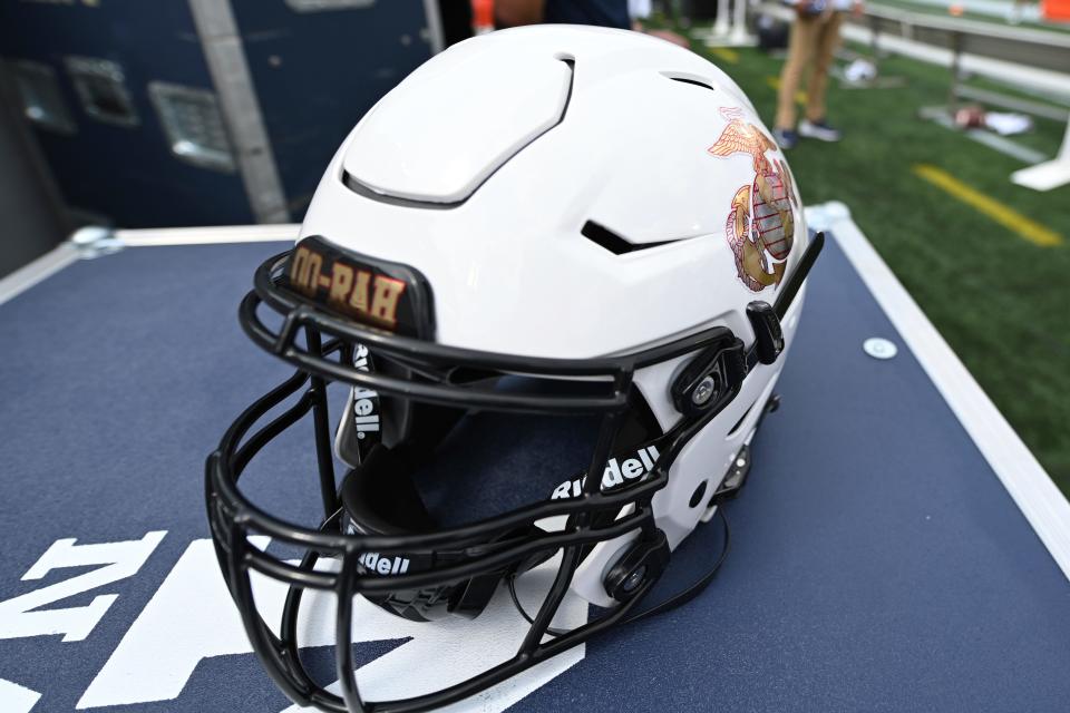 A Navy football helmet with a Semper Fi logo sits on the sideline before an NCAA college football game against Air Force, Saturday, Sept. 11, 2021.