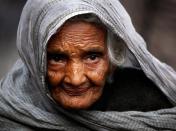 An elderly woman begs for alms on a roadside in the old part of New Delhi, India, Wednesday, Feb. 3, 2010. (AP Photo/Rajesh Kumar Singh)