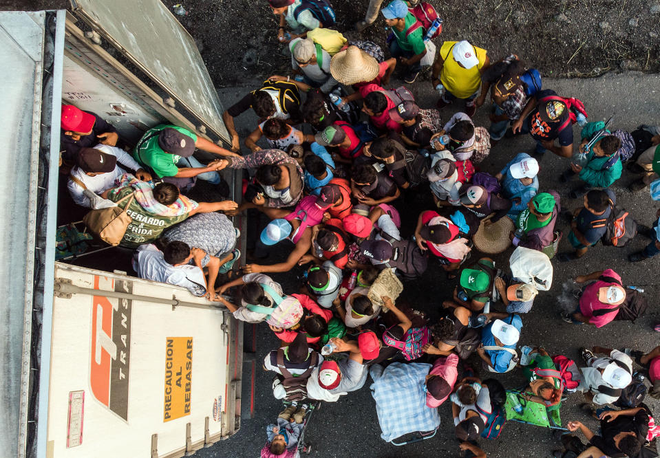 <p>Honduran migrants taking part in a caravan heading to the U.S. get on a truck near Pijijiapan, southern Mexico on Oct. 26, 2018. (Photo: Guillermo Arias/AFP/Getty Images) </p>