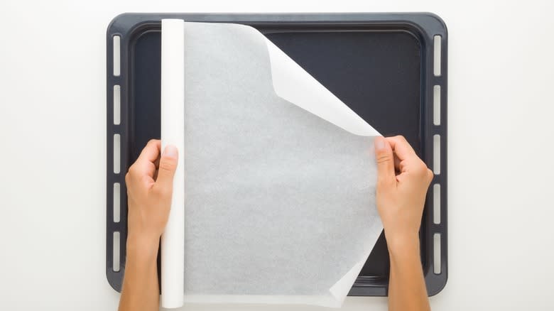 Person placing parchment on tray