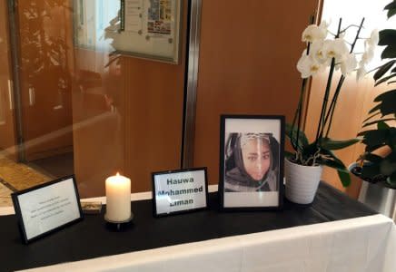 A view shows a table that was set up with a photo of Hauwa Mohammed Liman, a health worker abducted and murdered by her Islamist captors in Nigeria, along with a white orchid, burning candle and signing asking staff to leave condolence messages for her family, at the entrance of the ICRC headquarters in Geneva, Switzerland October 16, 2018. REUTERS/Stephanie Nebehay