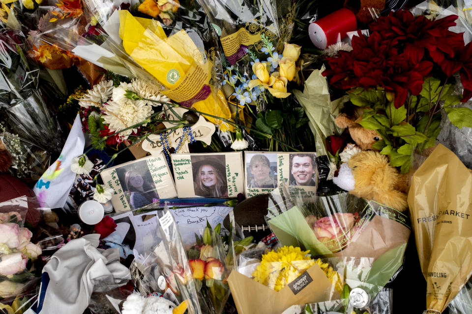 Photographs of four students, Hana St. Juliana, 14; Madisyn Baldwin, 17; Tate Myre, 16, and Justin Shilling, 17, sit among bouquets of flowers, teddy bears and other personal items left at the memorial site on Tuesday, Dec. 7, 2021 outside Oxford High School in Oxford, Mich., after a 15-year-old allegedly killed these four classmates, and injured seven others in a shooting inside the northern Oakland County school one week earlier. (Jake May/The Flint Journal via AP)