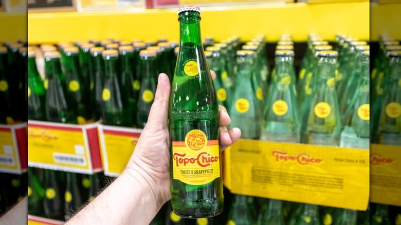 holding Topo Chico grapefruit bottle