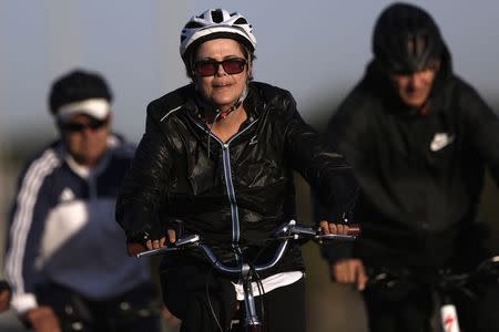 Brazil's President Dilma Rousseff rides her bicycle near the Alvorada Palace in Brasilia, July 27, 2015. REUTERS/Ueslei Marcelino