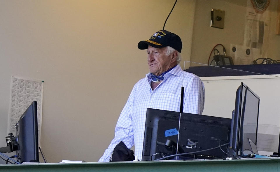 FILE - Milwaukee Brewers broadcaster Bob Uecker stands during the seventh inning of the team's baseball game against the Pittsburgh Pirates on Aug. 30, 2020, in Milwaukee. Uecker will be back behind the microphone when the Brewers play their home-opener Tuesday, April 3, against the Minnesota Twins. How heavy a broadcasting workload the 90-year-old Uecker will have the rest of the season remains uncertain. (AP Photo/Morry Gash, File)