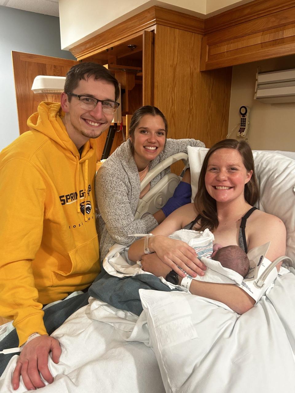 Oaklawn labor and delivery nurse Jaydn Comden, center, smiles for a photo with longtime friends Ian and Megan Fulton and baby girl Ellowyn.