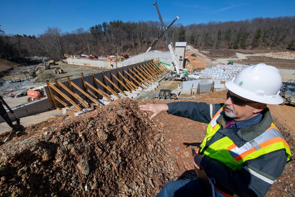 Steven Metzler, senior engineering project manager, describes how the Lake Williams dam project was 60 percent completed on March 16, 2023. Bracing is in place next to the valve tower on March 16, at right, that will help support the trapezoidal weir that be the primary path of water over the dam.