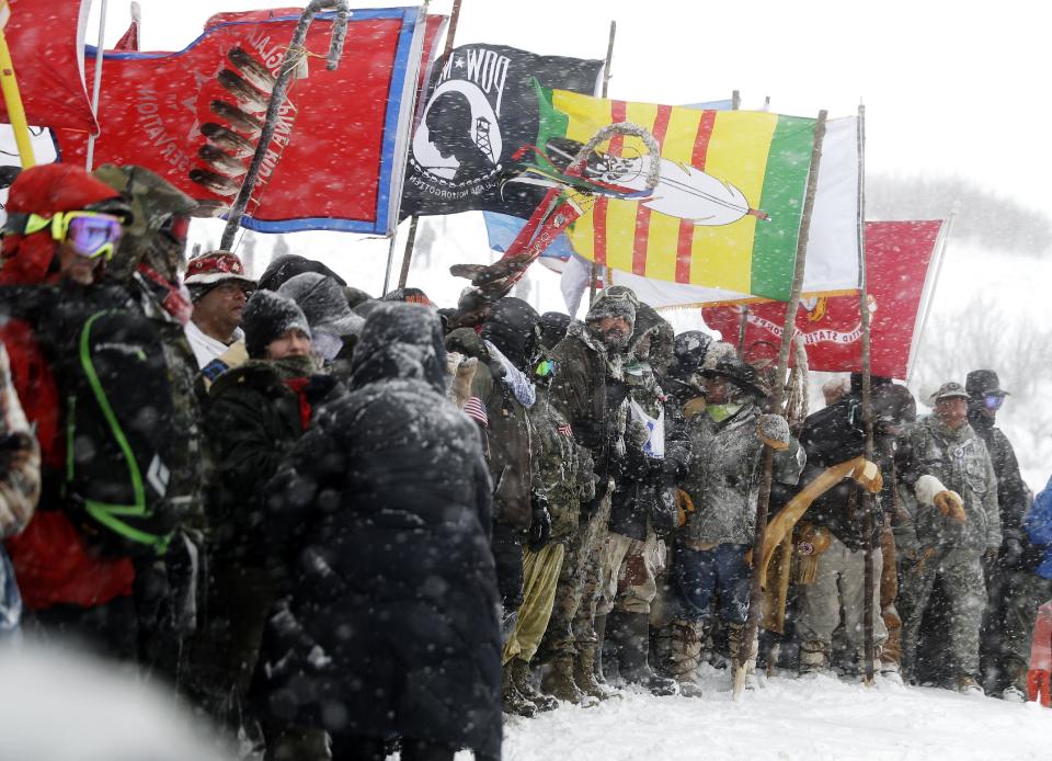 FILE - In this Dec. 5, 2016, file photo, military veterans and Native American tribal elders come to a stop for a ceremonial prayer during a march to a closed bridge across from the Dakota Access oil pipeline site in Cannon Ball, N.D. Some Native Americans worry the transition to a Donald Trump administration signals an end to eight years of sweeping Indian Country policy reforms. But Trump's Native American supporters said they're hopeful he will cut through some of the government red tape that they believe has stifled economic progress on reservations. (AP Photo/David Goldman, File)