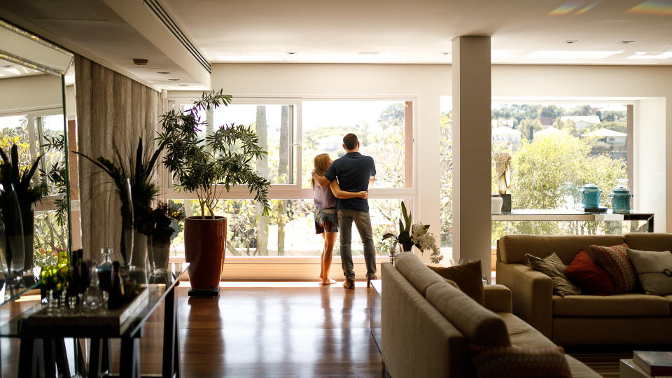 Couple admiring the view from the living room of their house.