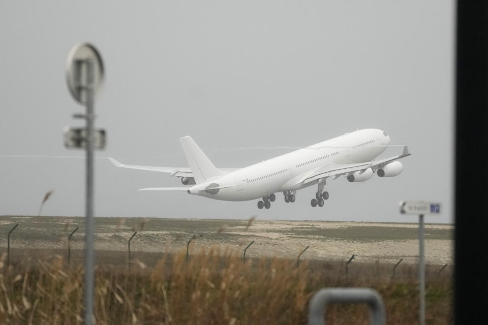 The plane grounded by police at the Vatry airport takes off Monday, Dec. 25, 2023 in Vatry, eastern France.The charter plane grounded in France for a human trafficking investigation departed on Monday for India, after an exceptional holiday ordeal that left about 300 Indians en route to Central America blocked inside a rural French airport for four days. (AP Photo/Christophe Ena)