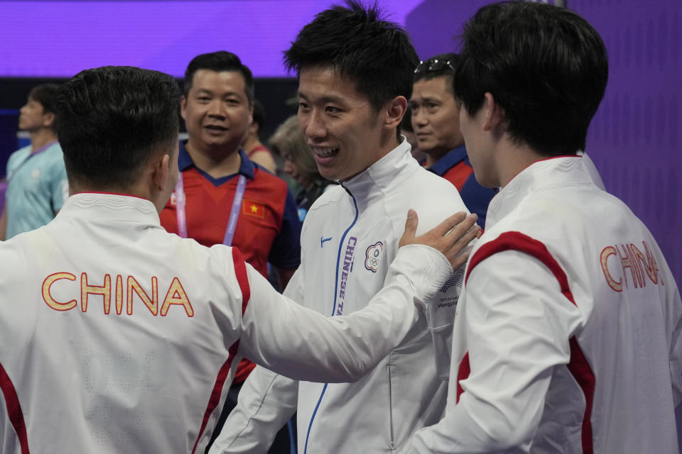 China's Lin Chaopan, at left congratulates Taiwan's Lee Chih Kai after he wins Artistic Gymnastics Men's Pommel Horse Final next to China's Zhang Boheng, at right during the 19th Asian Games in Hangzhou, China, Thursday, Sept. 28, 2023. At the Asian Games China has been going out of its way to be welcoming to the Taiwanese athletes, as it pursues a two-pronged strategy with the goal of taking over the island, which involves both wooing its people while threatening it militarily. (AP Photo/Ng Han Guan)