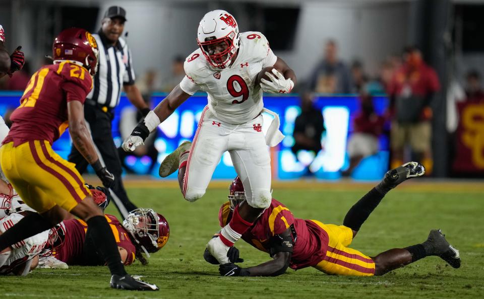 Utah running back Tavion Thomas (9) breaks a tackle by Southern California defnder Greg Johnson (1) during the third quarter of their 2021 game at United Airlines Field at Los Angeles Memorial Coliseum.