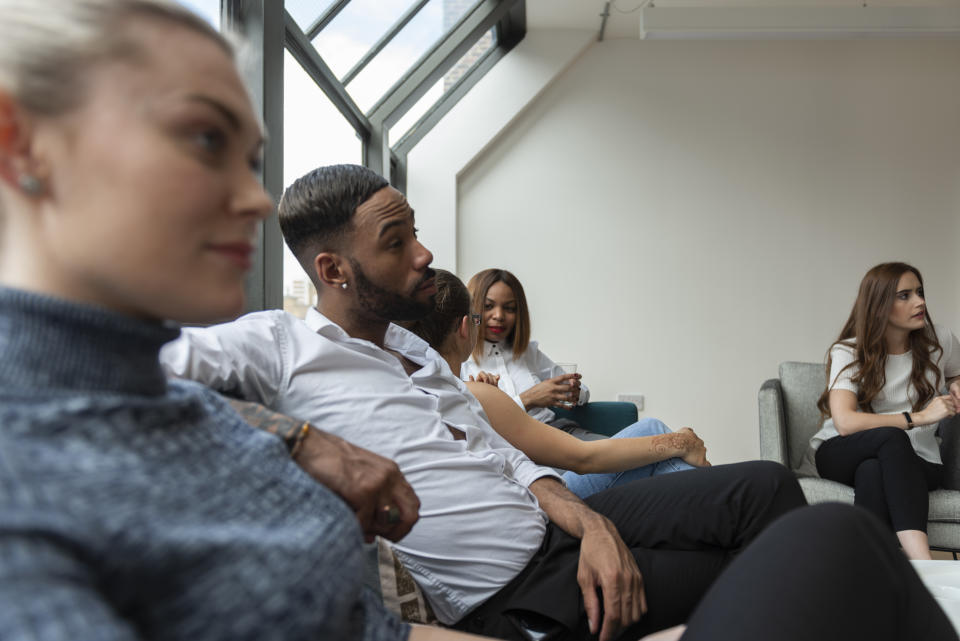 Group of young start-up entrepreneurs having meeting in an unofficial office. They are having a discussion and talking about their achievements.