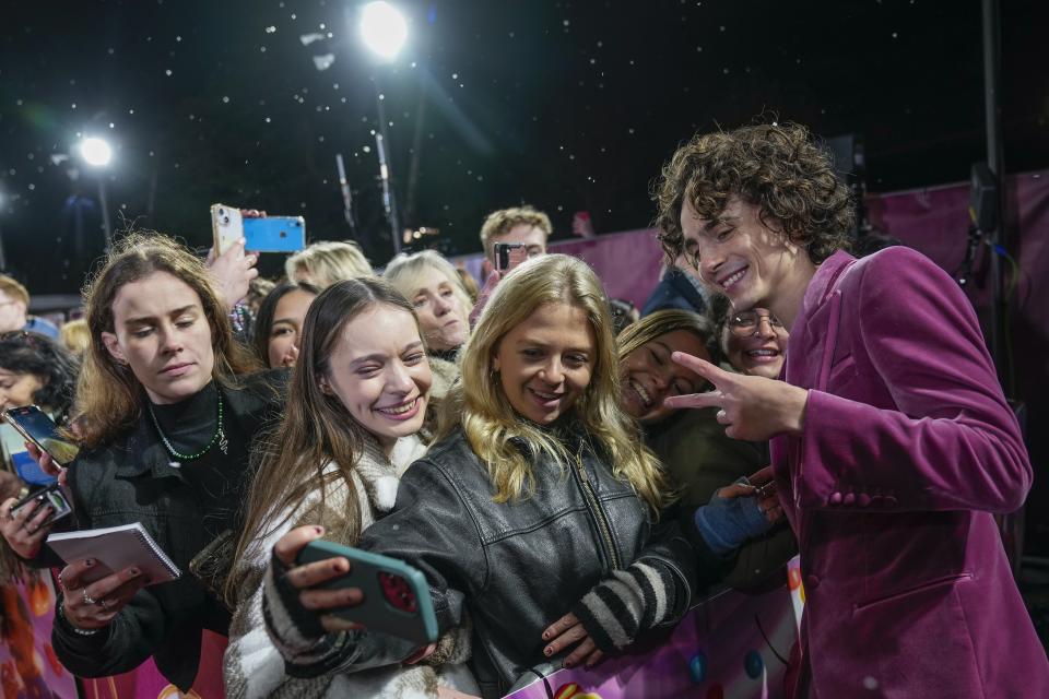 Timothee Chalamet, right, poses for photographs with fans upon arrival at the world premiere of the film 'Wonka' on Tuesday, Nov. 28, 2023 in London. (Scott Garfitt/Invision/AP)