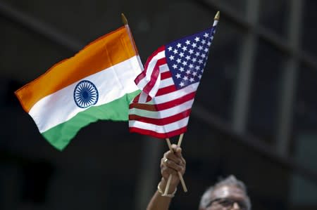 FILE PHOTO: Man holds the flags while people take part in the 35th India Day Parade in New York