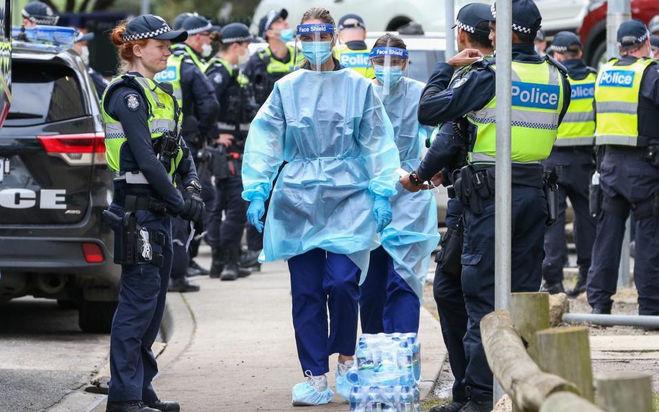 Medical staff wearing PPE enter the Flemington Public housing flats in Melbourne -  Asanka Ratnayake/Getty Images AsiaPac