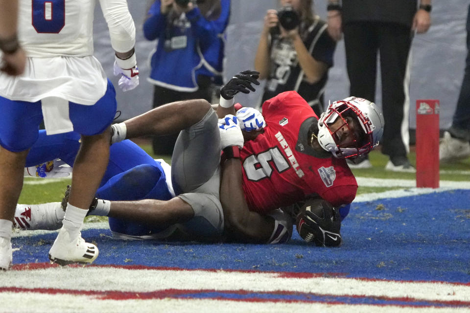 UNLV running back Vincent Davis Jr. scores a touchdown against Kansas during the first half of the Guaranteed Rate Bowl NCAA college football game Tuesday, Dec. 26, 2023, in Phoenix. (AP Photo/Rick Scuteri)