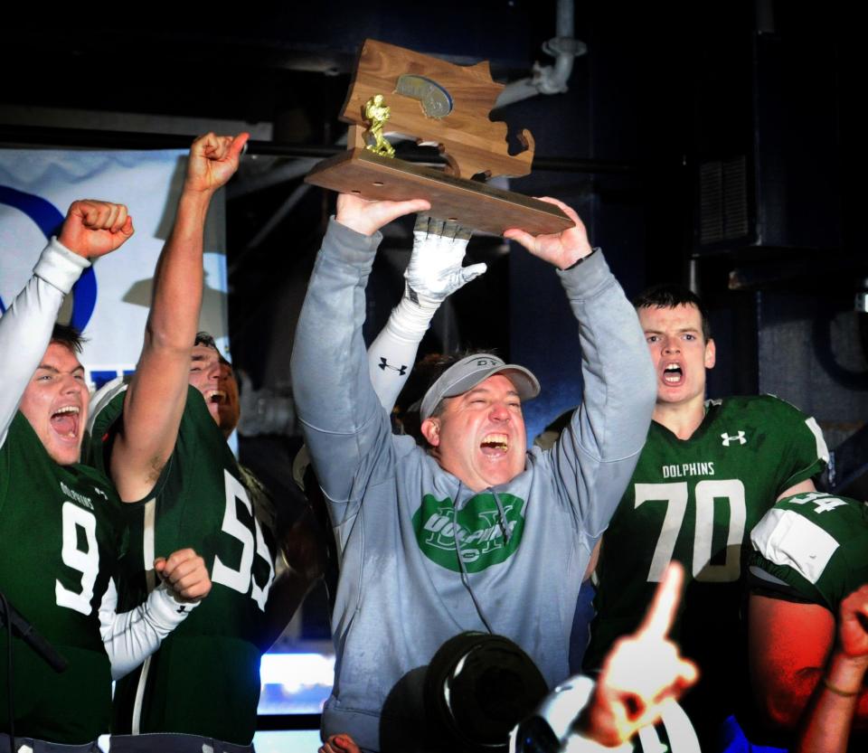 Dennis-Yarmouth head coach Paul Funk with the MIAA Div. 5 championship trophy after beating West Springfield in the Superbowl in December 2017.