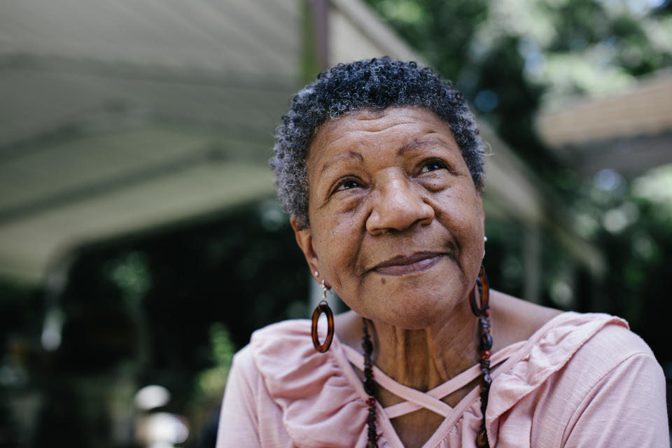 Close-up outdoor portrait of senior black woman looking thoughtful. Member of a black middle class America family.