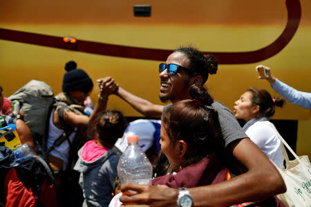 Central American migrants, moving in a caravan through Mexico, are welcomed by other migrants as they arrive from Puebla city at La Casa del Peregrino, a temporary shelter set up for them by the Catholic church, in Mexico City, Mexico April 9, 2018. REUTERS/Edgard Garrido