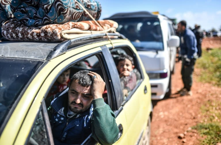 Syrians arrive at a checkpoint in the country's north on March 17, 2018 as civilians flee the city of Afrin