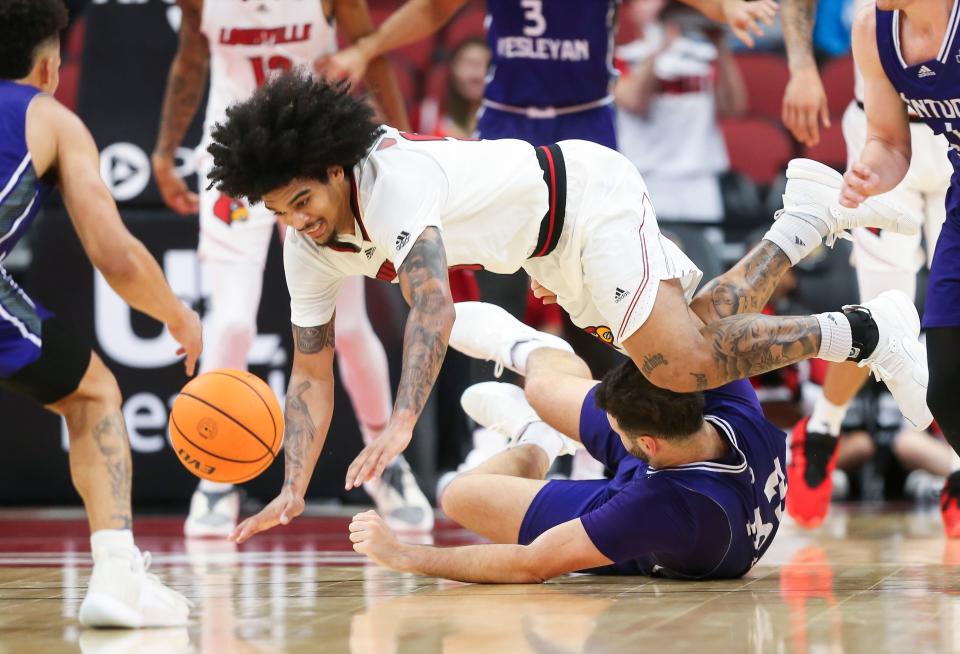 Louisville's Skyy Clark dives for the ball over Kentucky Wesleyan's Borja Fernandez in the second half. Louisville lost to Kentucky Wesleyan, 71-68, on Monday night.