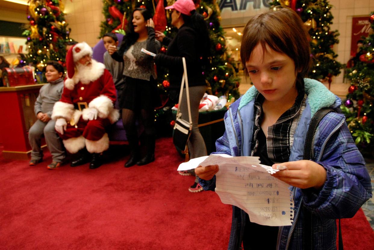Gabbie Bruce, 6, reviews her Christmas wish list letter as she waits to see Santa at the Jefferson Mall Saturday afternoon. Nov. 15, 2014
