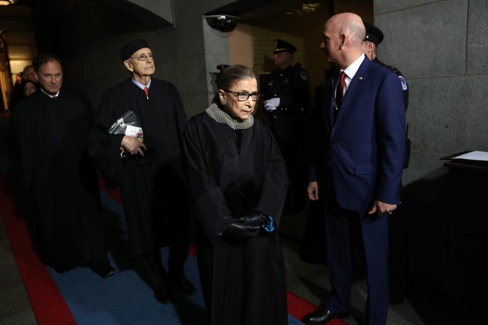 <p>Supreme Court Justices Samuel Alito (left), Ginsburg (in her "dissenting" collar) and Stephen Breyer (center) arrive at the U.S. Capitol to watch Trump as he was sworn in as president. </p><p>Before the 2016 election, <a href="https://www.cnn.com/2016/07/12/politics/justice-ruth-bader-ginsburg-donald-trump-faker/index.html" rel="nofollow noopener" target="_blank" data-ylk="slk:Ginsburg said;elm:context_link;itc:0;sec:content-canvas" class="link ">Ginsburg said</a>, "I can't imagine what this place would be–I can't imagine what the country would be–with Donald Trump as our president." She later said <a href="https://www.npr.org/2016/07/14/486012897/ginsburg-apologies-for-ill-advised-trump-comments" rel="nofollow noopener" target="_blank" data-ylk="slk:her statement;elm:context_link;itc:0;sec:content-canvas" class="link ">her statement</a> was "ill-advised."</p>