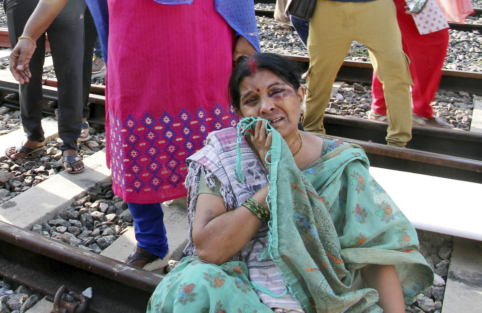 A woman, injured in a train coach fire, cries by a railway track in Madurai, in the southern Indian state of Tamil Nadu, Saturday, Aug. 26, 2023. A gas cylinder smuggled in by some passengers caused the fire killing nine people, according to a statement by the Southern Railway. (AP Photo)