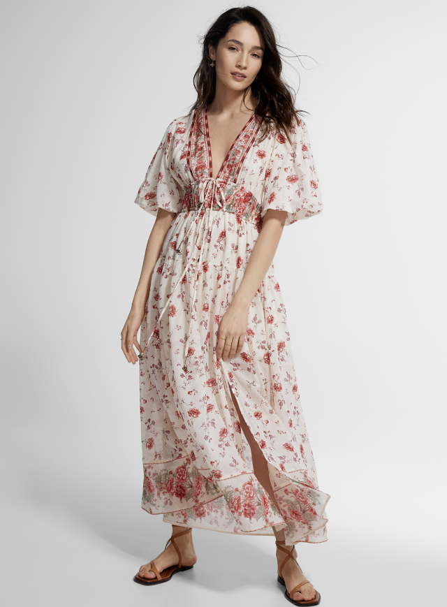 brunette model in red and white floral Carmine Peonies Long Flared Dress (photo via Simons)