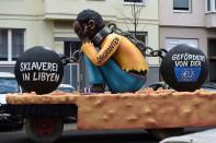 <p>A carnival float, depicting a migrant with chains with the writings “Slavery in Libya” and “supported by the EU”, is pictured during a carnival parade on Rose Monday on Feb. 12, 2018 in Duesseldorf, western Germany. (Photo: Patrik Stollarz/Getty Images) </p>