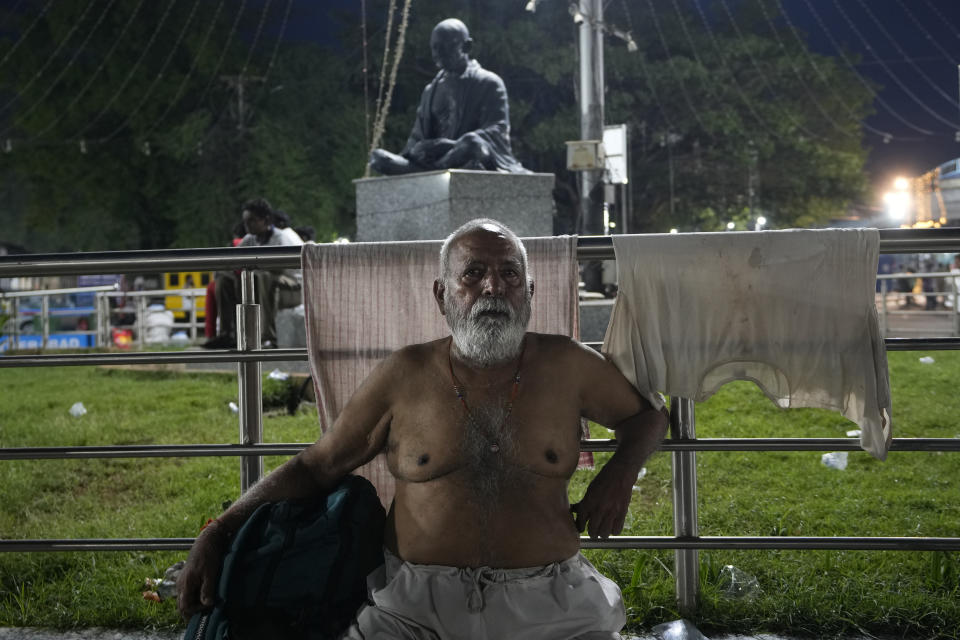 Vishnu Das Demla, who travelled from the central Indian city of Gwalior, sits next to his laundry after getting a fish therapy for his ailment, in Hyderabad, India, Saturday, June 8, 2024. Every year thousands of asthma patients arrive here to receive this fish therapy from the Bathini Goud family, which keeps a secret formula of herbs, handed down by generations only to family members. The herbs are inserted in the mouth of a live sardine, or murrel fish, and slipped into the patient's throat. (AP Photo/Mahesh Kumar A.)