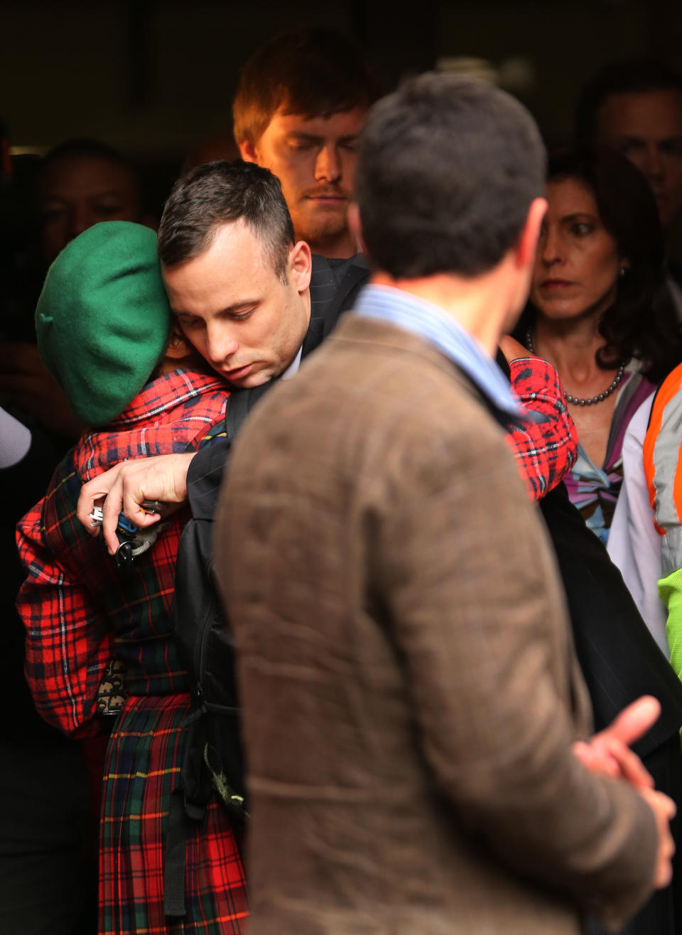 Oscar Pistorius, center, shares a hug with unidentified woman as he leaves the high court in Pretoria, South Africa, Wednesday, April 16, 2014. Pistorius is charged with murder for the shooting death of his girlfriend, Reeva Steenkamp, on Valentines Day in 2013. (AP Photo/Themba Hadebe)