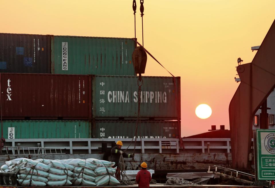 Workers loading ships at a port in Nantong, in China's eastern Jiangsu province, on March 9, 2018.