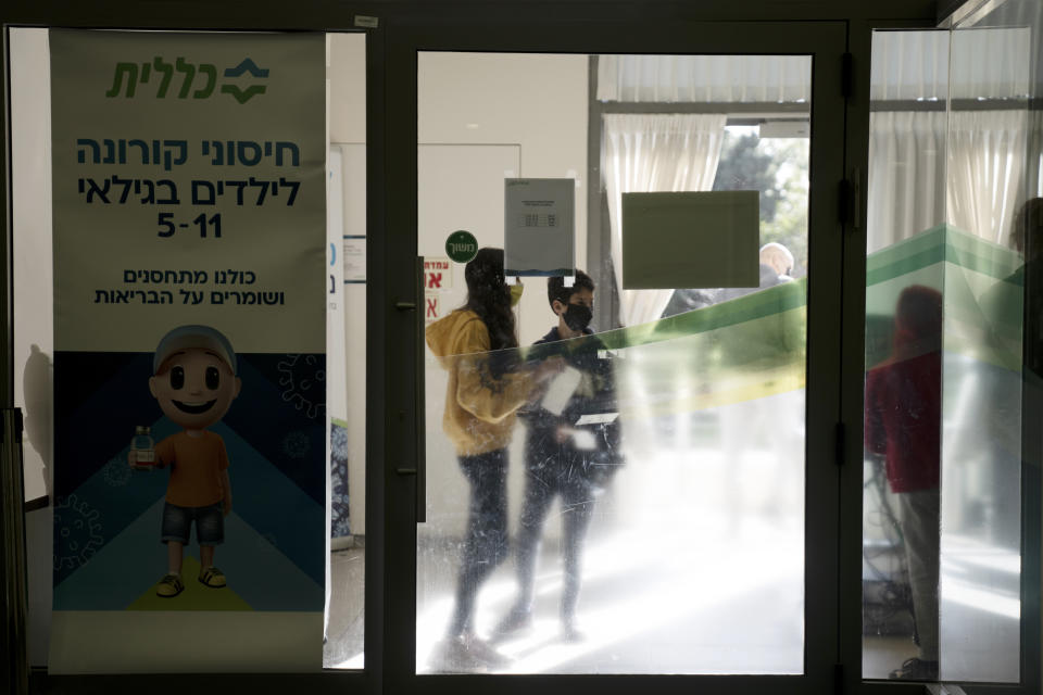 Siblings wait to receive the COVID-19 vaccine at Clalit Health Services in Mevaseret Zion, Tuesday, Jan. 11, 2022. (AP Photo/Maya Alleruzzo)