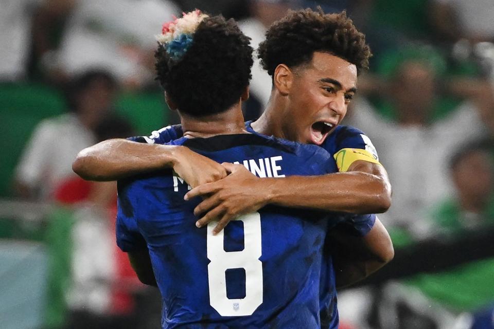 USMNT's Weston McKennie (8) and teammate Tyler Adams celebrates their first goal against Iran during their World Cup match at the Al-Thumama Stadium in Doha, Qatar on Nov. 29, 2022.