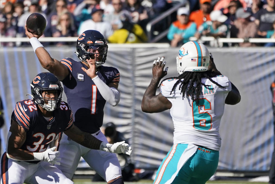 Chicago Bears quarterback Justin Fields (1) passes past Miami Dolphins linebacker Melvin Ingram (6) as running back David Montgomery (32) blocks during the first half of an NFL football game, Sunday, Nov. 6, 2022 in Chicago. (AP Photo/Charles Rex Arbogast)