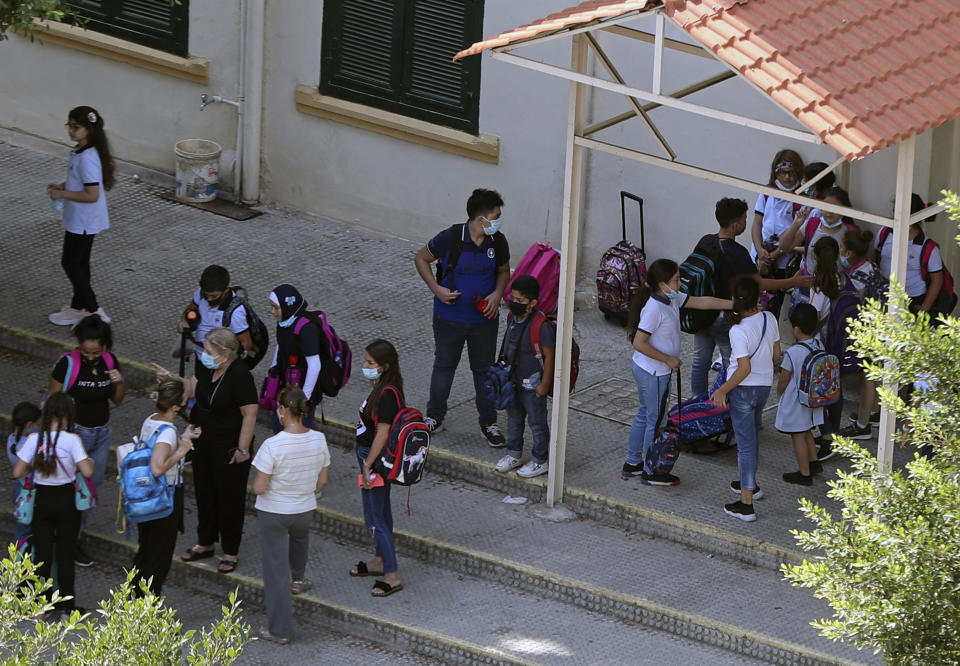 Students leave their school in Beirut, Lebanon, Wednesday, Sept. 29, 2021. Lebanese students are returning to schools, many for the first time since late 2019, but the country's crippling economic crisis is threatening to derail the first in-class academic year after the pandemic. Public school teachers are on strike, demanding their pay be adjusted to make up for the collapse of the national currency, and a severe fuel shortage threatens to keep classrooms dark. (AP Photo/Bilal Hussein)