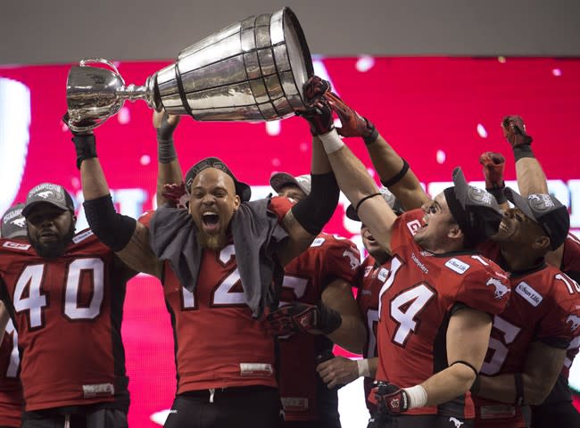 The top of the Grey Cup trophy came loose as Calgary linebacker Juwan SImpson raised it in celebration Sunday night. (Paul Chiasson/The Canadian Press.)