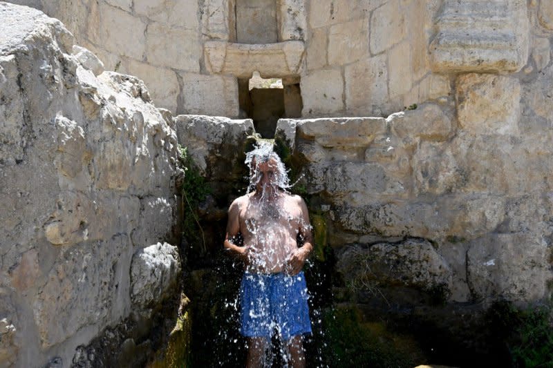 A visitor cools off in a fountain from the Roman period in the Haniya Natural Spring in the Judean Mountains National Park in Israel on July 15 amid a severe heat stress warning. File Photo by Debbie Hill/UPI