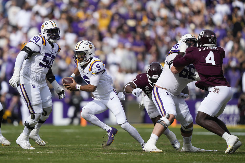 LSU quarterback Jayden Daniels (5) scrambles under pressure in the first half of an NCAA college football game against Texas A&M in Baton Rouge, La., Saturday, Nov. 25, 2023. (AP Photo/Gerald Herbert)