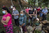 La Reina residents left homeless when their community was buried in an epic mudslide triggered by Hurricanes Eta and Iota, attend an outdoor Mass at Mission San Francisco de Asis, Honduras, Sunday, June 27, 2021. It was the the first time in recorded history that successive Category 4 and 5 Atlantic hurricanes slammed the same place. (AP Photo/Rodrigo Abd)