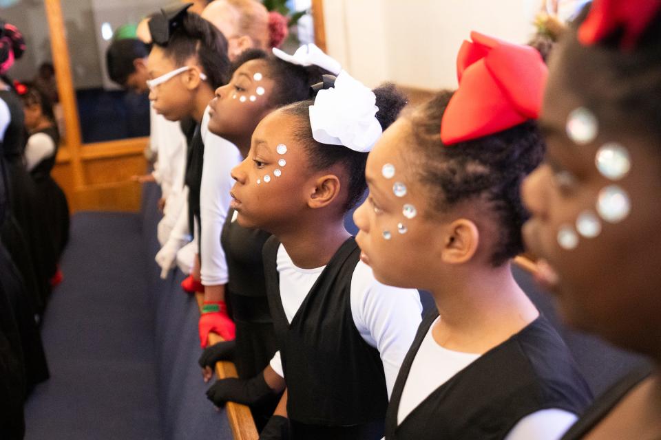 Dancers with the Butterflies and OSAO (Our Steps Are Ordered) Dance Ministry listen to actors performing during a special Easter program held on Palm Sunday, March 24, at the Family Missionary Baptist Church in Columbus.