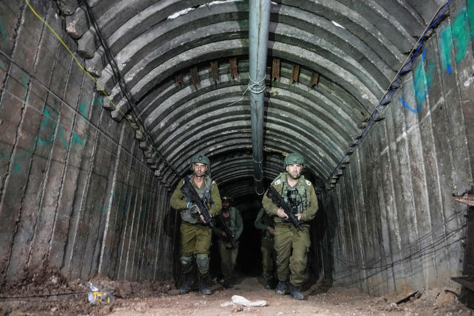 Israeli soldiers are seen in a tunnel that the military says Hamas militants used to attack the Erez crossing in the northern Gaza Strip, Friday, Dec. 15, 2023. The army is battling Palestinian militants across Gaza to retaliate for Hamas' Oct. 7 attack on Israel. (AP Photo/Ariel Schalit)